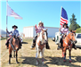 Fair Ambassadors riding horses holding flags and ribbon